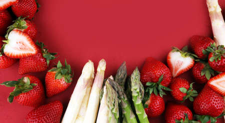 White and green fresh asparagus with a bunch of healthy strawberriesの写真素材