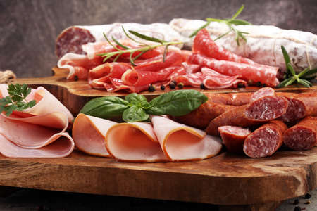 Food tray with delicious salami, ham,  fresh sausages and herbs. Meat platter with selection.の写真素材