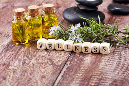lavender oil in a glass bottle on a background of fresh flowers and Wellness sign with wooden cubesの写真素材