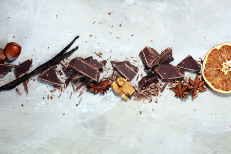 dark chocolate bars  with anise and nutson stone table and broken pieces of cocoa.の写真素材