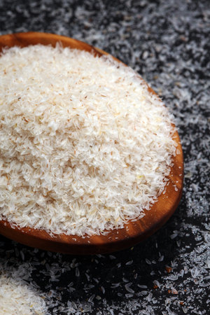 Portion of Psyllium Seeds on rustic dark background. Psyllium seed husks.