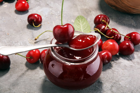 Rustic jar with cherry jam and fresh cherries, homemade preserves.の写真素材