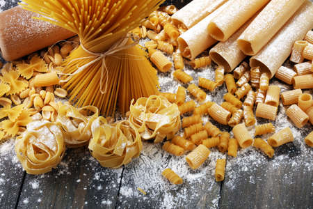 Various mix of pasta on grey rustic background. Making homemade pastaの写真素材