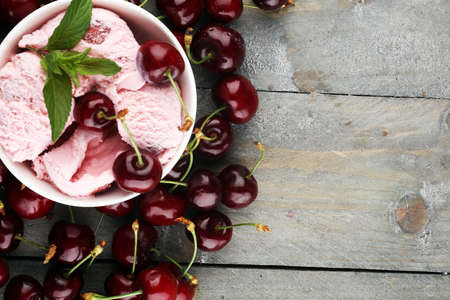 Homemade cherry ice cream and a bunch of cherries on table.の写真素材