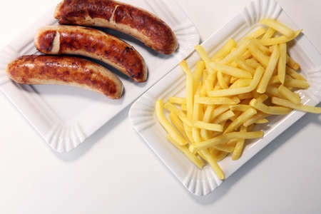 Grilled sausage served with french fries or fried potatoes with sausage.の写真素材