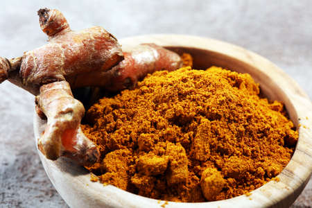 Turmeric powder and fresh turmeric on grey background.の写真素材