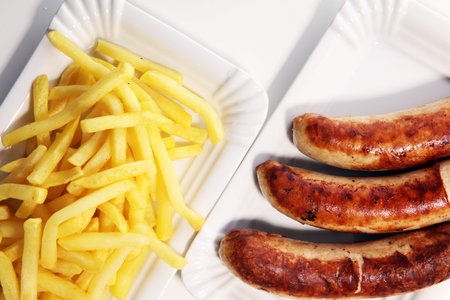 Grilled sausage served with french fries or fried potatoes with sausage.