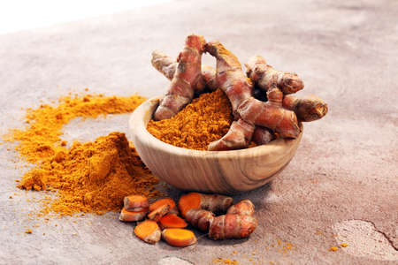 Turmeric powder and fresh turmeric on grey background.の写真素材