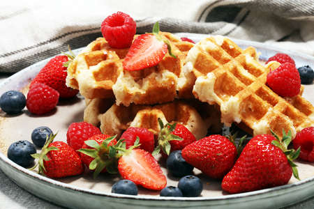 Traditional belgian waffles with fresh fruits. Bakery with strawberry, raspberry and blueberryの写真素材