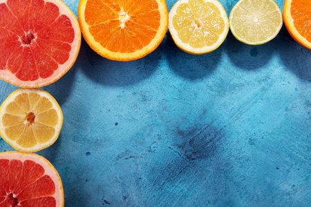 Citrus fruits with orange, lemon, grapefruit and lime on blue background