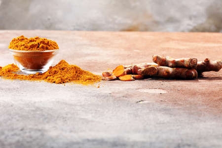 Turmeric powder and fresh turmeric on grey background.の写真素材