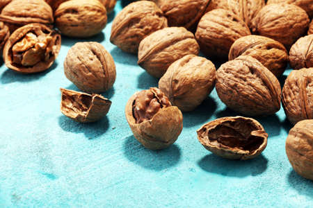 Walnut kernels and whole healthy walnuts on rustic old tableの写真素材