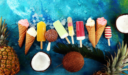 Vanilla frozen yogurt or soft ice cream in waffle cone and Colorful ice cream with tropical fruits