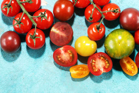 Colorful Organic Tomatoes on table. Fresh Organic Red Yellow Orange and Green Tomatoes.の写真素材