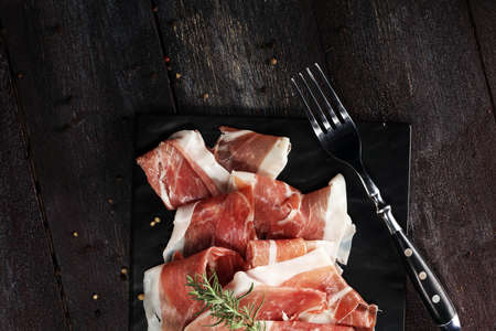 Italian prosciutto crudo or jamon with rosemary. Raw ham.の写真素材
