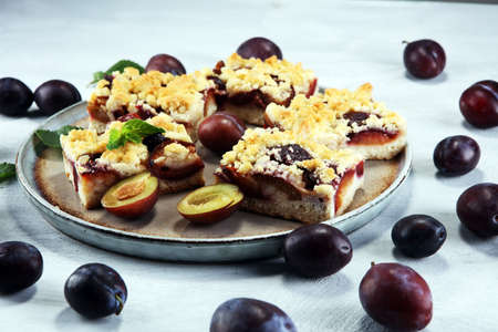 Rustic plum cake on wooden background with plums aroundの写真素材