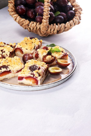 Rustic plum cake on wooden background with plums aroundの写真素材