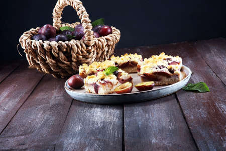 Rustic plum cake on wooden background with plums aroundの写真素材