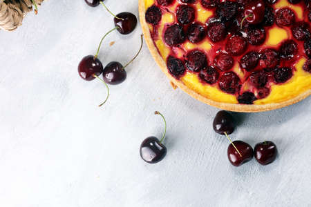 cherry cake and a bunch of cherries on table.の写真素材
