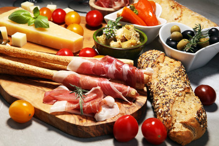 Italian antipasti wine snacks set. Cheese variety, Mediterranean olives, crudo, Prosciutto di Parma,...