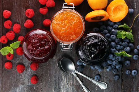 assortment of jams, seasonal berries, apricot, mint and fruits. marmalade or confitureの写真素材
