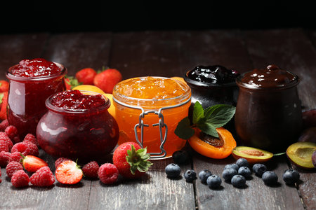assortment of jams, seasonal berries, apricot, mint and fruits. marmalade or confitureの写真素材