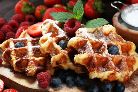Traditional belgian waffles with fresh mint, sugar and raspberries, blueberries and strawberriesの写真素材