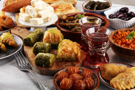 Middle eastern or arabic dishes and assorted meze, concrete rustic background. sambusak. Turkish Dessert Baklava with pistachio. Sarma, Rice and mint wrapped in grape vine leaves. Halal food. Lebanese cuisineの写真素材