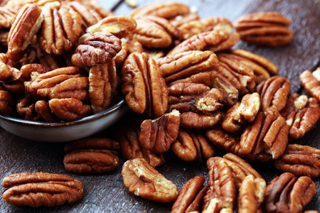 Pecan nuts on a rustic wooden table and pecan nuts in bowl.