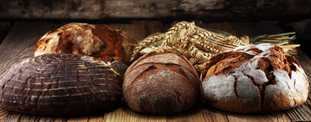 Different kinds of bread and bread rolls on board from above. Kitchen or bakery poster design.