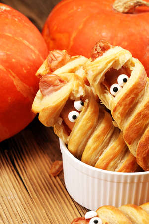 Mummy sausages scary halloween party food decoration wrapped in doughの写真素材