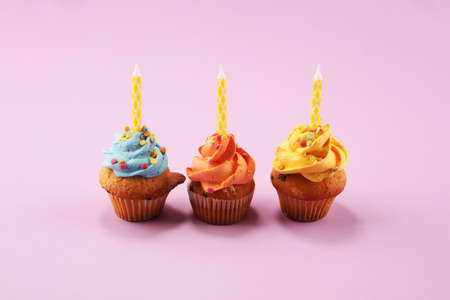 Tasty cupcakes on pinke background. Birthday cupcake in rainbow colorsの写真素材