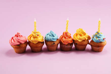 Tasty cupcakes on pinke background. Birthday cupcake in rainbow colorsの写真素材