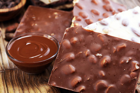 Chocolate bars on table with chocolate tower. Chocolate and nuts