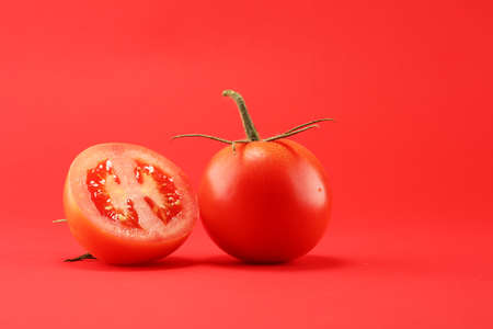 tomato on red background. italian healthy vegan food concept with tomatoesの写真素材