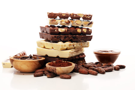 Chocolate bars on table with chocolate tower. Chocolate and nuts