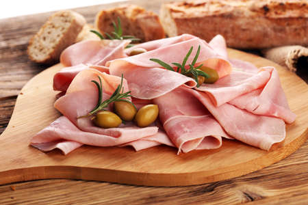 Sliced ham on wooden background. Fresh prosciutto. Pork ham sliced.の写真素材