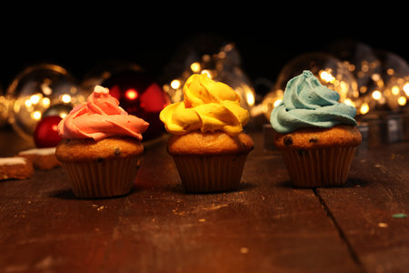 Tasty cupcakes on christmas winter background. Birthday cupcake in rainbow colorsの写真素材
