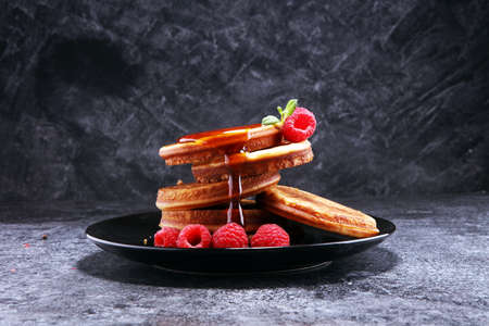 Pancakes with berries and maple syrup on rustic table.の写真素材