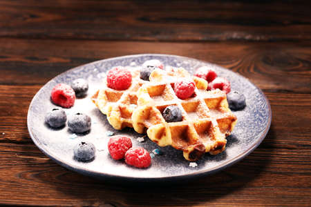 waffles with fresh blueberries, sugar and raspberriesの写真素材