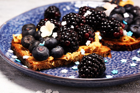 Delicious Tasty Homemade peanut butter toast or bread with blackberries and blueberries