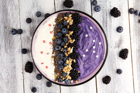 Healthy breakfast. smoothie bowl with blackberries and granola on rustic background.
