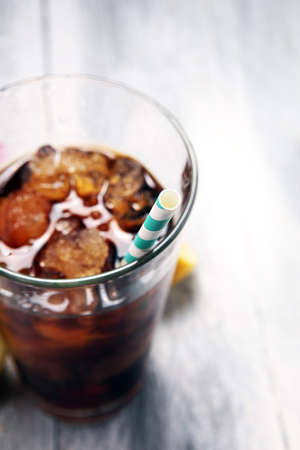 Softdrink with ice cubes, lemon and straw in glass.の写真素材
