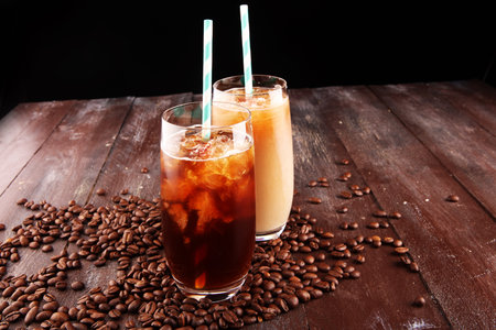 Ice coffee on a rustic table with cream being poured into it showing the texture and refreshing look...