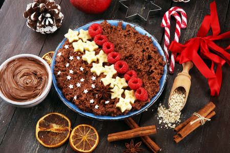 Bowl of cacao oatmeal porridge with banana, raspberries coconut and caramel sauce on rustic table, hot and healthy food for Breakfast.の写真素材