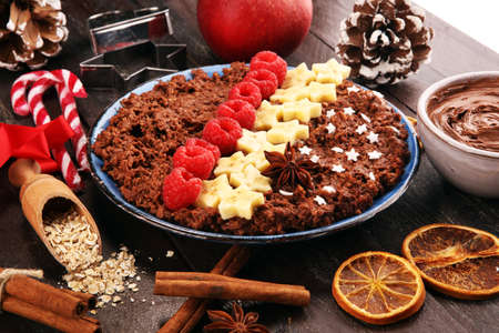 Bowl of cacao oatmeal porridge with banana, raspberries coconut and caramel sauce on rustic table, hot and healthy food for Breakfast.の写真素材