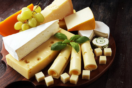 Cheese plate served with grapes, various cheese on a platter.の写真素材
