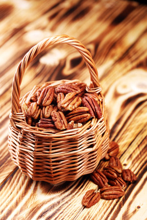 Pecan nuts on a table and pecan nuts in bowl.