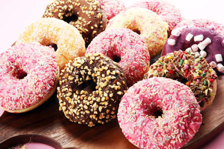 assorted donuts with chocolate frosted, pink glazed and sprinkles donuts.の写真素材
