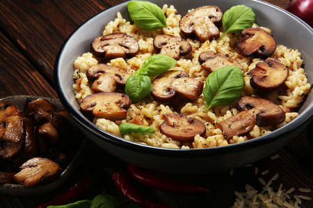 risotto with mushrooms, fresh herbs and parmesan cheese and basilの写真素材